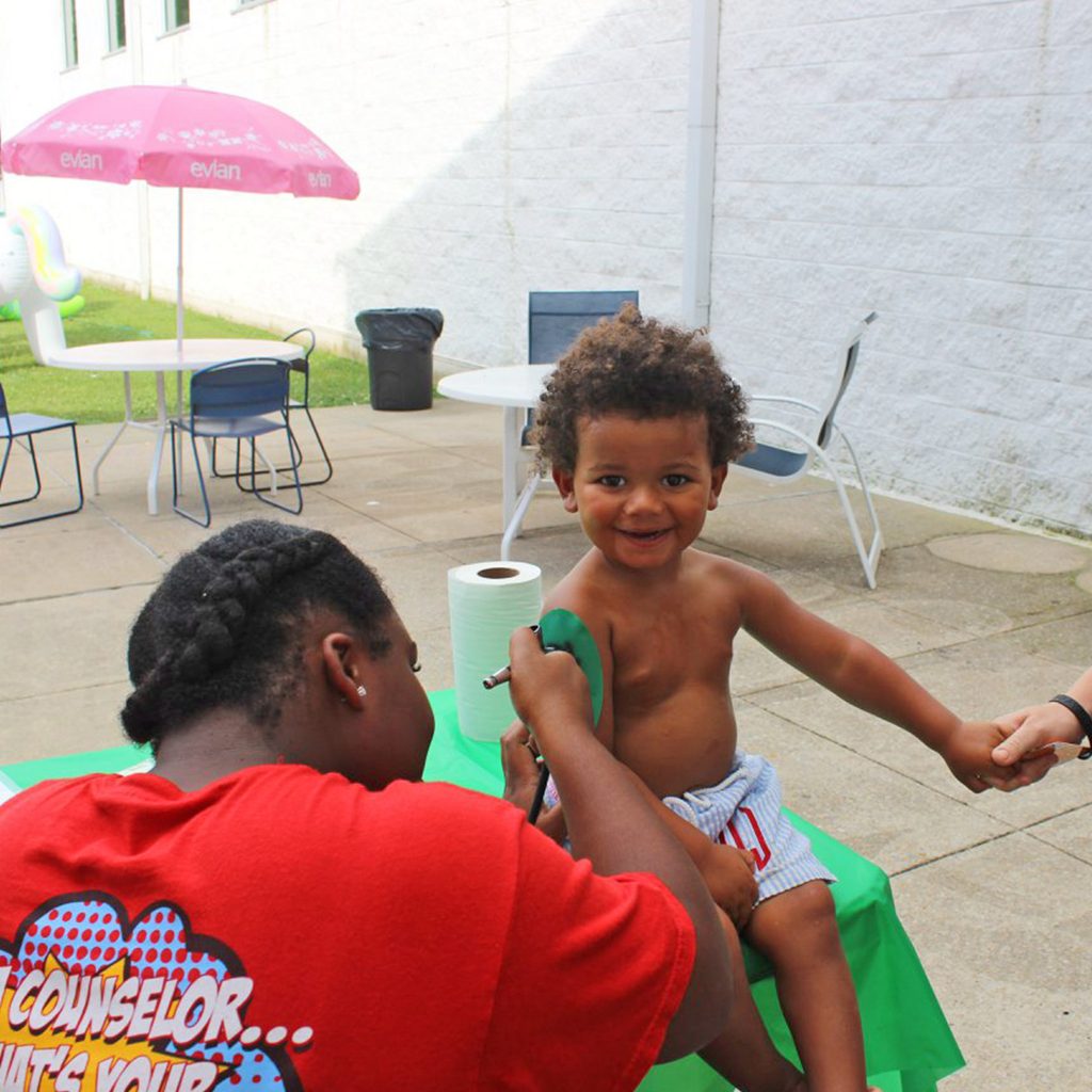 Counselor with a young boy at the pool area